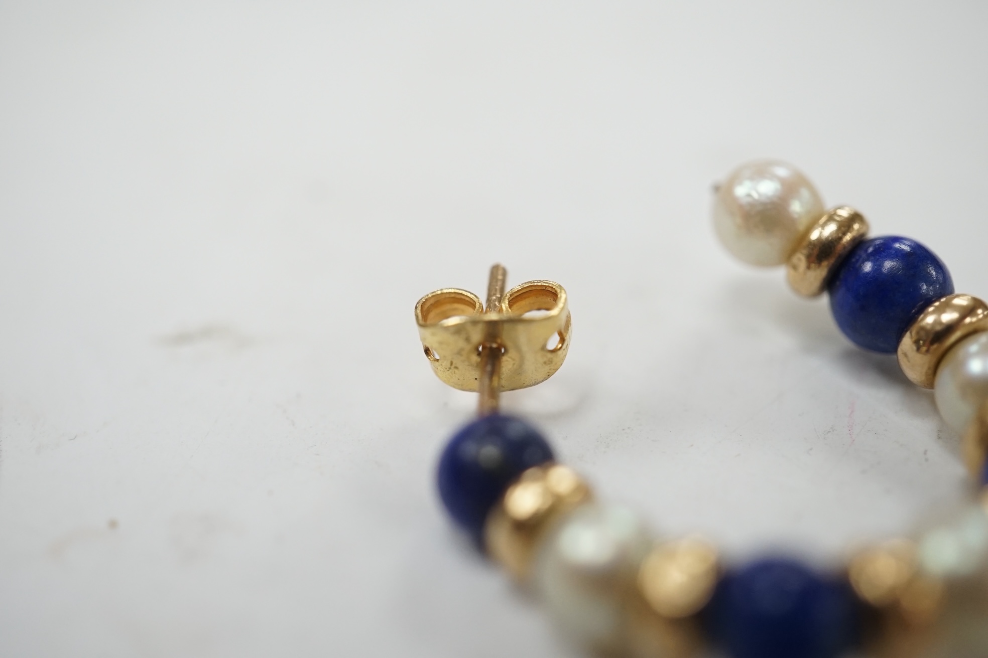 A modern pair of yellow metal lapis lazuli and and cultured pearl cluster set half hoop earrings, 25mm. Condition - fair to good